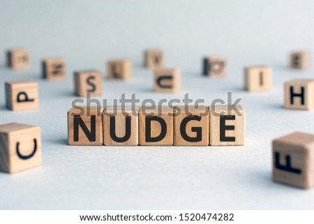 Nudge - word from wooden blocks with letters, pushing gently concept, random letters around, white  background Royalty-Free Stock Photo #1520474282