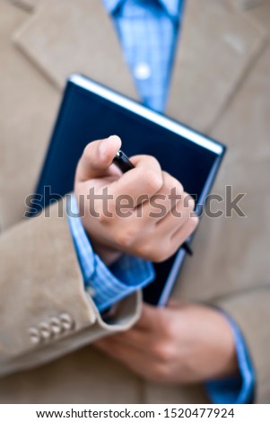 Manager at office, holding agenda and pen, office work, doing business
