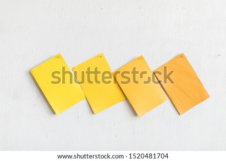 Yellow leather cowhide swatches on white wall, copy space