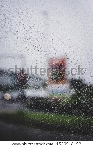 View through a car's windscreen of a rainy miserable day with traffic and car lights thrown out of focus - English weather. 