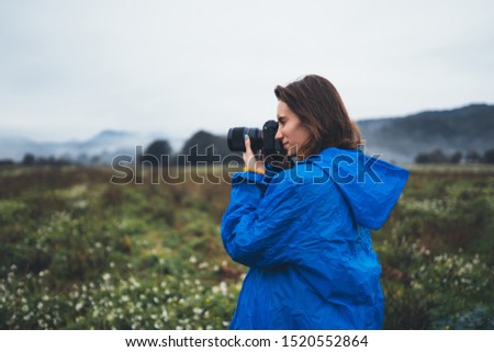 photographer tourist girl in blue raincoat hold in female hands photo camera take photography foggy mountain, traveler shooting autumn nature, click on camera technology, journey landscape vacation