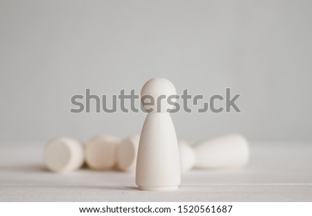standing wooden doll in front of falling group