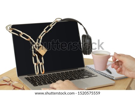 young woman drinks coffee from a small pink cup front of a laptop on which an iron chain with a lock hangs, concept of computer danger, protection of information on the Internet, close up, copy space