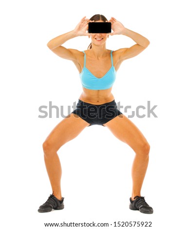 Attractive cheerful young fitness woman showing blank smartphone screen isolated over white background