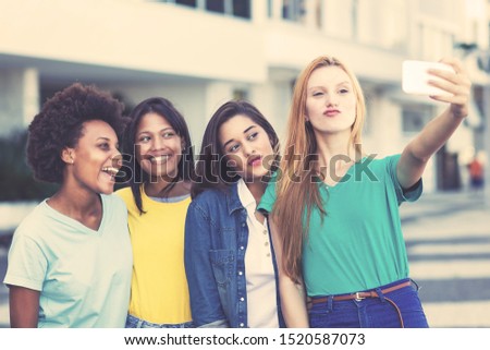 Group of international young adult woman taking crazy selfie outdoor in summer in city