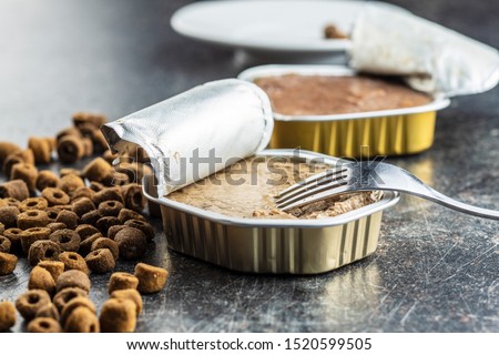 Wet and dry pet food. Cat or dog pate on old table. Royalty-Free Stock Photo #1520599505