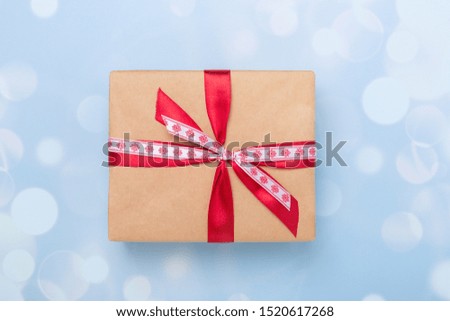 Christmas gift box and bokeh decoration on blue background. Top view with copy space - Image