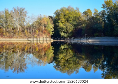 Autumn landscape. A lake and yellow and green trees, reflecting in the waterl, Baden-Wuerttemberg, Germany.