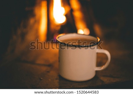 Hot chocolate in mug by the fireplace during autumn
