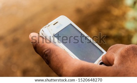 A hand of a man tayping with an old mobile