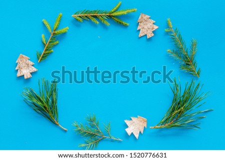 New Year decorative mockup. Fir branches and festive toys frame on blue background top view copy space