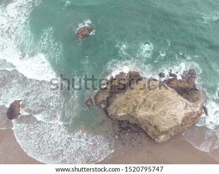 Abstract texture of water with waves and sand and rocks. Top view of turquoise water as background, ocean, sea, lake