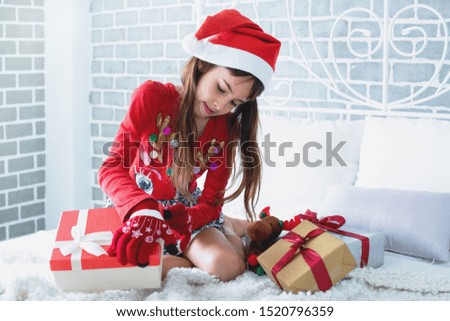 Portrait of cheerful Asian little child girl with Christmas gifts in bed on Christmas morning 