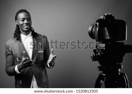 Young handsome African businessman against brown background