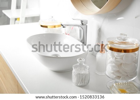 Cotton swabs and pads near sink on white countertop
