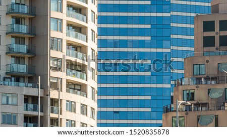 Modern multi-dwelling buildings with  balconies, zoom close up. Apartments in a strata living scheme of common property, offices or commercial buildings. Royalty-Free Stock Photo #1520835878