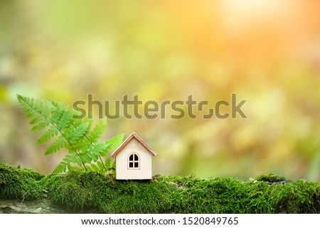 Wooden toy house in forest, abstract natural background. Symbol of Family. Construction, rental housing, Mortgage, Real estate concept. Eco Friendly home. template for design. copy space