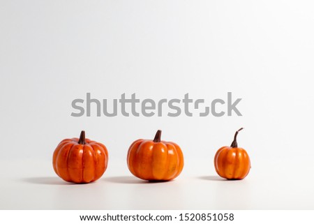 three orange pumpkins over a white background