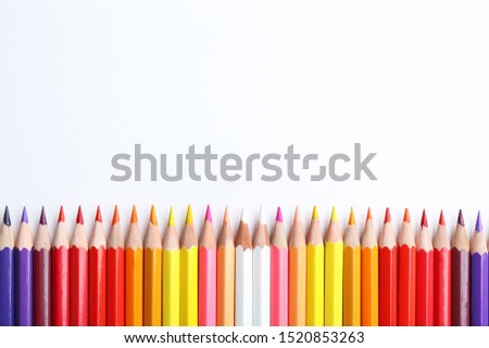 Composition with color pencils on white background, flat lay. Space for text