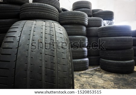 Irregular Tire Wear , Damaged black tire of side wear area on blurred pile old tyres background. Royalty-Free Stock Photo #1520853515