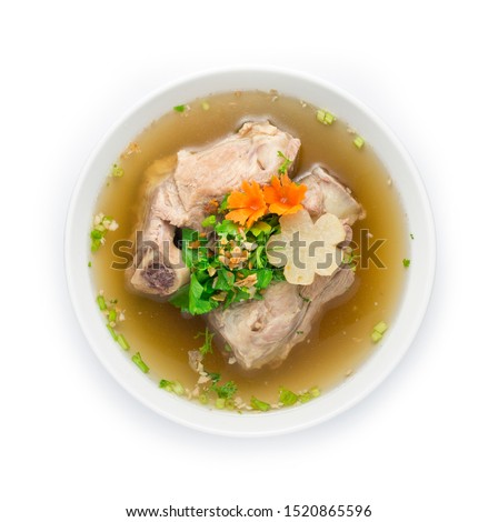 Pork Bone in Clear Soup popular Stock topped with celery cutlet . Asian Food fusion style decorate carved carrot and turnip top view