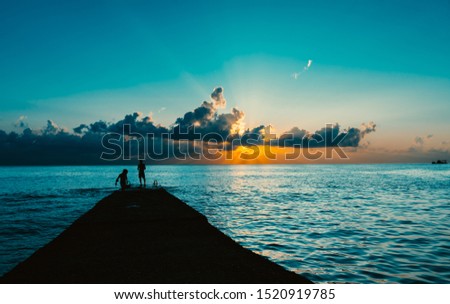 sunset at sea, silhouette of people on the pier