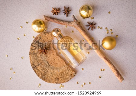 
gold perfume bottle with wood fragments, golden balls, anise stars and sparkles Royalty-Free Stock Photo #1520924969
