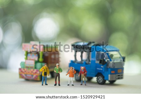 Miniature people : Traveller backpacker standing with Thai farming trucks and Thai style taxi. Travel and Adventure concepts in Thailand