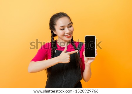 Pretty asian woman holding smartphone and pointing finger to the smartphone. 
