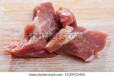 Close up of raw pork slices on wooden surface, nobody