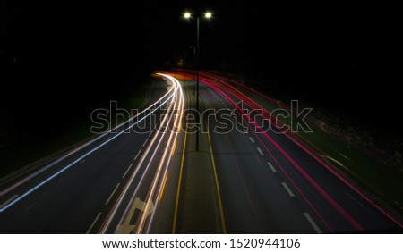 Long Exposure Picture from some cars traveling by in the dark. Very mystic picture with can be used in many settings.