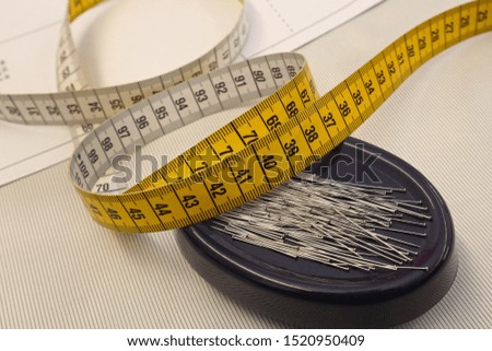 tape measure and pins on white background