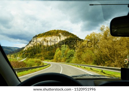 View of the road with a beautiful mountain landscape from the car window in a nice summer or autumn day