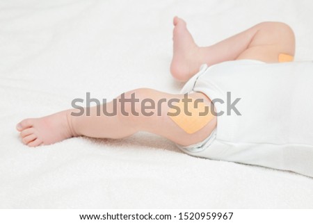Adhesive bandage on infant leg after injection of vaccine. Two month old baby. Body part. Medical concept. Closeup.  Royalty-Free Stock Photo #1520959967
