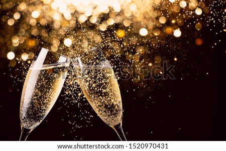 Two glasses of champagne toasting in the nigh with lights bokeh, glitter and sparks on the background Royalty-Free Stock Photo #1520970431