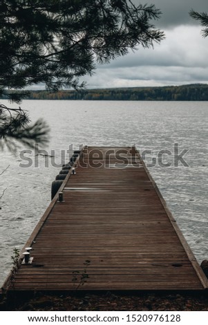 A gloomy and grey picture of a lonely wooden pier.