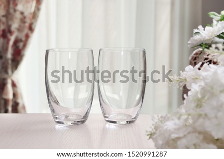 Pair of stemless wine glasses in cozy interior, product mock-up