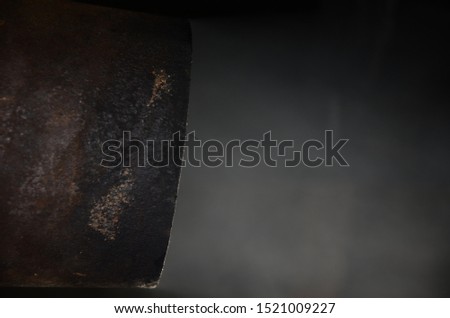 Smoke coming out of a rusty chimney pipe in dark surrounding
