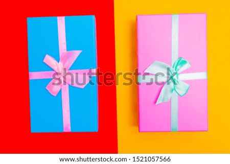 colored boxes with ribbons on a colorful background. view from above. gift with a bow.
