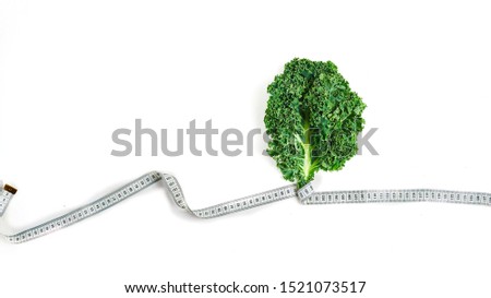 kale wrapped in measuring tape, concept diet, slimming, healthy eating top view, on white background