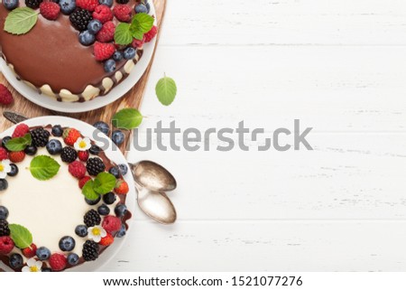 Chocolate cake and cheesecake with berries. On wooden table with copy space. Top view flat lay