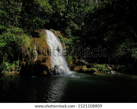BONITO, MATO GROSSO DO SUL, BRAZIL   -  waterfall in the Formoso river, hidden in the shadows of the forest, illuminated by a beam of sunlight.