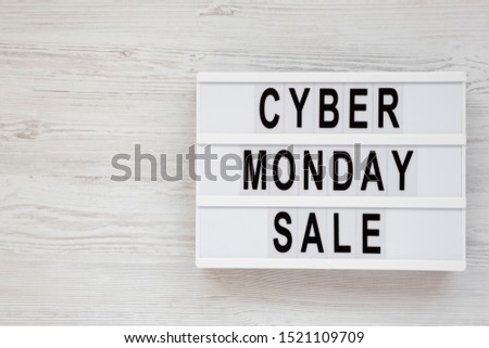 'Cyber monday sale' words on a modern board on a white wooden surface, top view. Overhead, from above, flat lay. Copy space.