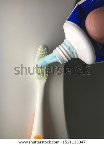 hand putting blue Toothpaste on toothbrush Detail Macro shot health dental products objects Dental Health supplies Macro shot Buy made of alternative compositions on white stone marble.