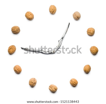 walnuts clock with nutcracker as hands on white background