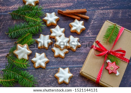Christmas gingerbread star shaped   cookies and christmas gift with red ribbon on   wooden background. Christmas card  background 