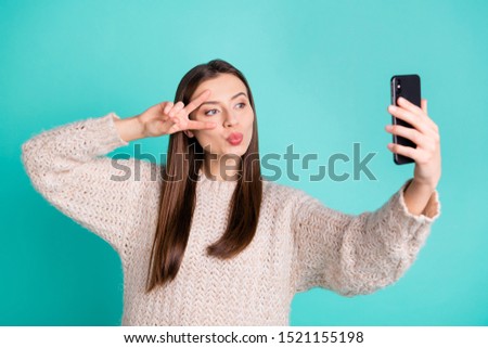 Portrait of charming lovely girl make selfie v-signs send air kisses to her blog followers wear white knitted pullover  jumper isolated over teal turquoise color background