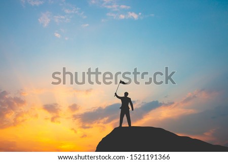 Motivation for trying to succeed in business, Silhouette of man on mountain top over sky and sun light background,business, success, leadership, achievement and people concept