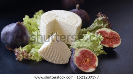 white cheese with lettuce and fresh figs on a black background