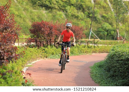 Woman cyclist riding mountain bike outdoors